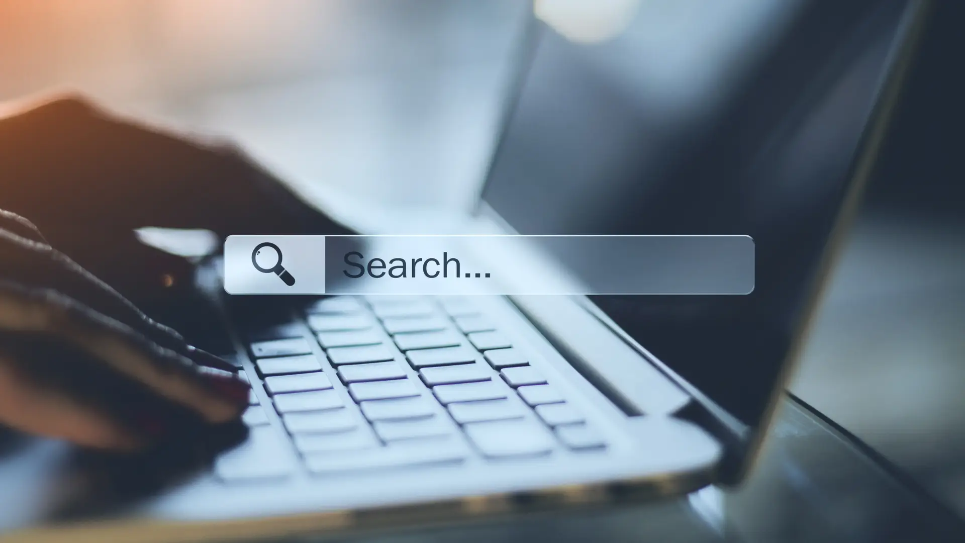 Lokalni SEO Srbija : Google search bar i ruke koje kucaju pretragu na laptop-u